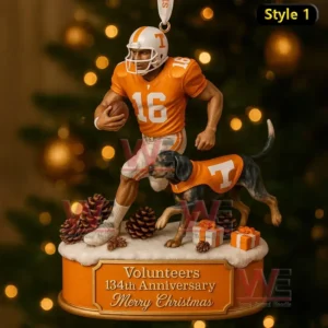A Tennessee Volunteers Christmas ornament featuring a number 16 player with a dog in an orange jersey on a snowy base with gifts and pinecones.