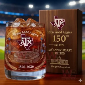 Texas A&M Aggies 1876-2026 150th Anniversary Whiskey Glass 5 A Texas AM themed drink glass with ice beside a wooden anniversary box in front of a lit stadium background!