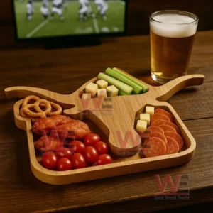 A longhorn shaped wooden tray filled with assorted snacks sits on a wooden table next to a glass of beer with a sports screen in the background!