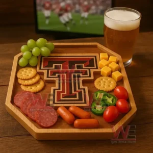 An emblem themed wooden tray filled with assorted snacks sits on a wooden table next to a glass of beer with a sports screen in the background!