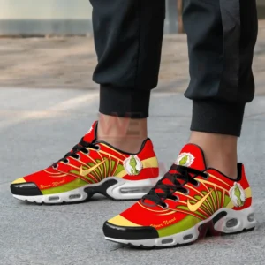 Alt text: A pair of festive Grinch-themed Air Max Plus TN sneakers with red, green, and yellow accents, featuring a Grinch character on the side.