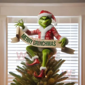 Green festive character tree topper holding a holiday banner on a Christmas tree.