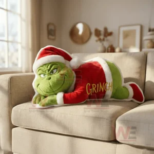 A holiday themed green character pillow lying on a beige sofa in a softly lit living room!