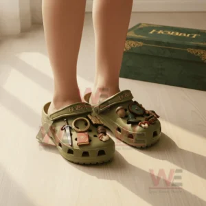 Person wearing olive green The Hobbit Crocs decorated with detailed fantasy charms including ring and sword.