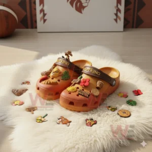 Orange The Lion King Crocs with Simba and Hakuna Matata charms surrounded by themed decorations on a white rug.