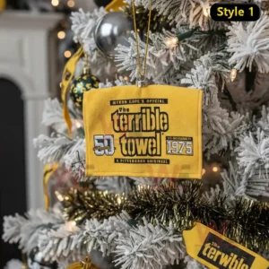 A yellow towel shaped ornament hangs from a frosted Christmas tree decorated with gold black and silver ornaments.