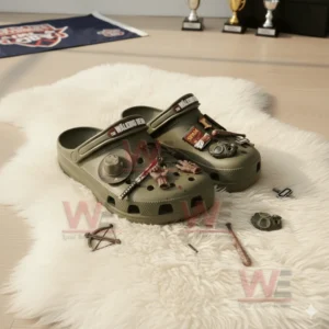 Olive green The Walking Dead Crocs surrounded by survival props and themed charms on a soft rug.