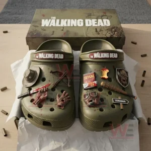 Boxed olive green The Walking Dead Crocs with detailed zombie and weapon charms.