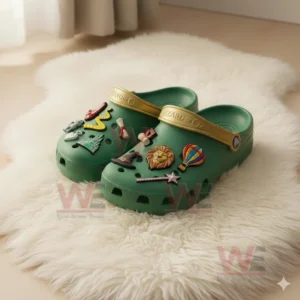 Green The Wizard of Oz Crocs with golden straps and themed charms including ruby slippers, wand, and hot air balloon.