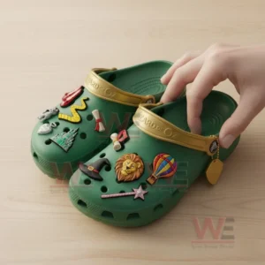 The Wizard of Oz Crocs Clogs with Charms 7 Close-up of green The Wizard of Oz Crocs with fantasy-themed charms being held by a hand.