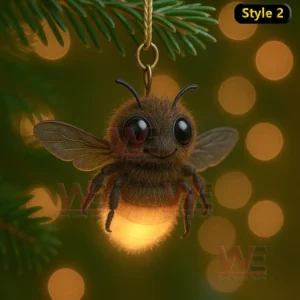 Glowing bee ornament with fuzzy texture hanging from pine branch.