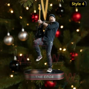 A guitarist ornament posing with a guitar on a platform hanging before a Christmas tree.