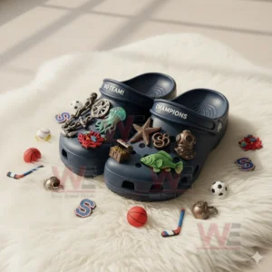 Blue undersea themed clogs resting on a white fluffy mat surrounded by various charms.