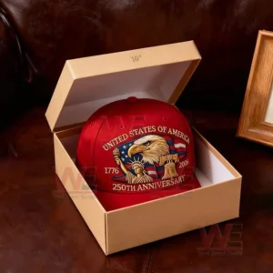 A red anniversary cap sits inside an open beige gift box on a leather surface.