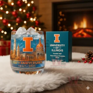 University Of Illinois 158th Anniversary Whiskey Glass 3 University of Illinois 158th anniversary glass with ice and box placed near a fireplace and Christmas decorations.