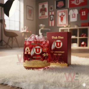 Utah Utes 1892-2026 134th Anniversary Whiskey Glass 4 A red Utah Utes themed drink glass beside an anniversary box inside a decorated sports room!