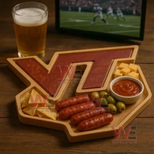 An emblem shaped wooden tray filled with assorted snacks sits on a wooden table next to a glass of beer with a sports screen in the background!