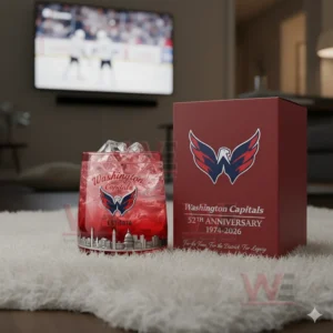 A red themed Washington Capitals anniversary glass on a white rug with a hockey game on a television behind it!