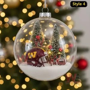 A glass Christmas ornament featuring a Santa Claus in Washington Commanders gear beside a fireplace with stockings and gifts.