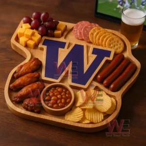 A wooden snack board arranged with grapes cheese cubes sliced meats crackers sausages chicken wings baked beans and chips surrounding a large purple letter W!
