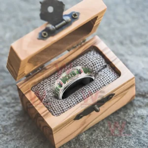 Silver ring with patterned Wicked themed band inside an open wooden gift box!