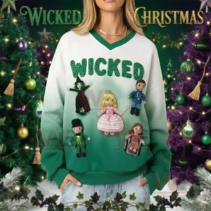 A green and white V neck sweatshirt with Wicked lettering and attached crochet dolls worn in a holiday setting!