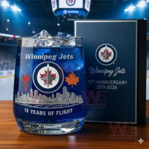 A Winnipeg Jets glass and box displayed on a wooden surface with an illuminated stadium visible behind them!