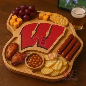 A wooden snack board arranged with grapes cheese cubes crackers sausages chicken wings baked beans and chips surrounding a large red letter W!