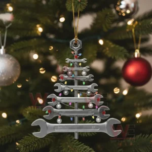 Wrench shaped Christmas tree ornament hanging on a green tree with lights.