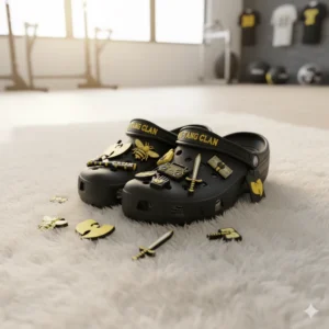 Black Wu Tang Clan Crocs with gold themed charms on white rug.
