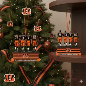 Four football players in black and orange uniforms standing on a display base hanging on a Christmas tree.