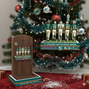 Five Dolphins players standing on a display base hanging in front of a Christmas tree with a matching stand beside it.