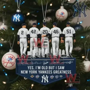 Alt text: A close-up of a Yankees ornament with figurines of players set against a Christmas tree decorated with Yankees-themed ornaments.