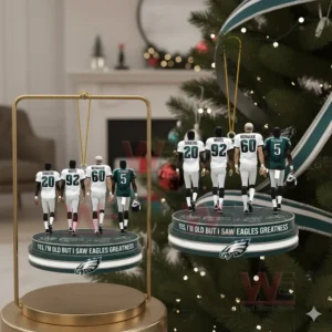Four Eagles players standing on a team themed ornament base in front of a Christmas tree.