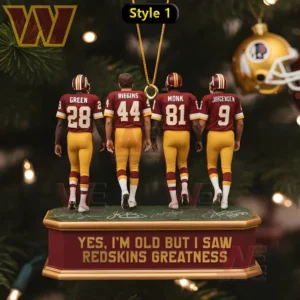 Four small football figures stand on a hanging base in front of a Christmas tree.