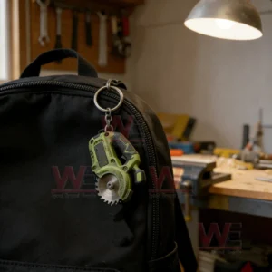 Green mini saw keychain attached to a black backpack inside a woodworking workshop!