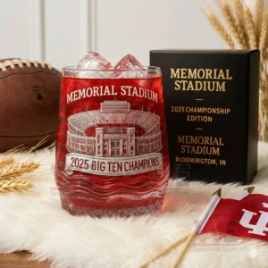 Etched Memorial Stadium glass with red beverage and ice next to a black championship box on a white fur surface!