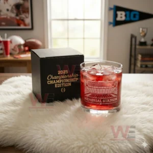 2025 Big Ten Champions Memorial Stadium Etched Whiskey Glass 4 Memorial Stadium etched glass with red drink and ice sitting beside a black box in a sports decorated room!