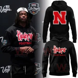 A black hoodie worn by a man featuring Nebraska Huskers Football text displayed at a Las Vegas Bowl background!