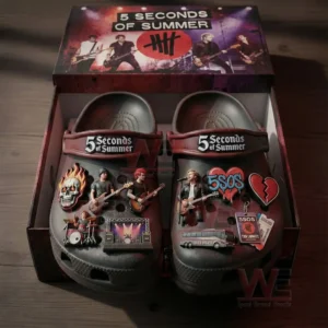 Black themed clogs inside a display box covered with music band charms figures logos and performance motifs on the upper surface!