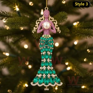 Mermaid shaped ornament with pink and green jeweled details hanging on a Christmas tree!