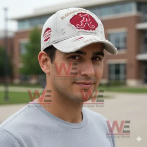 Portrait of a young man outdoors wearing a light gray distressed Alabama Crimson Tide cap with a red A logo and torn fabric details.