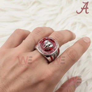 Hand wearing Alabama Crimson Tide ring with red gemstone face and elephant emblem.