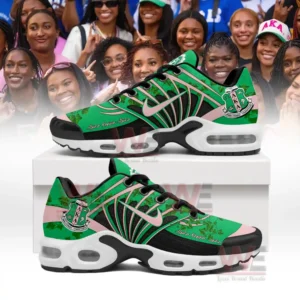 Green and pink shoes with ivy patterns and AKA crest displayed in front of a group photo of smiling women!