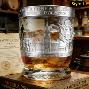 Commemorative American heritage whiskey glass with engraved symbols filled with amber whiskey on a wooden box in a classic bar environment!