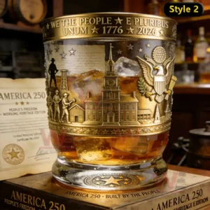 America 250 1776-2026 Whiskey Glass 5 Gold accented American heritage whiskey glass with detailed engravings and amber whiskey in a refined bar setting!