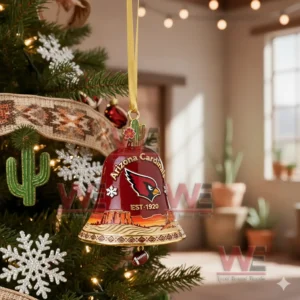 A red Arizona Cardinals themed bell ornament hanging on a decorated Christmas tree with desert inspired imagery and bright holiday lighting!