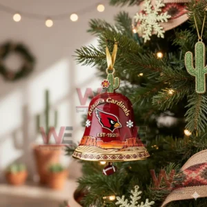 A red Arizona Cardinals bell ornament hanging on a Christmas tree with cactus decorations and warm seasonal lighting!