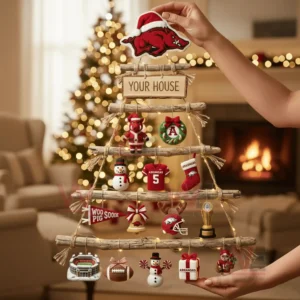 A handcrafted wooden branch Christmas wall tree decorated with Arkansas Razorbacks themed ornaments held by a person in a cozy festive living room!