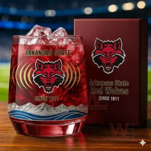 A close up image of a red drink with ice inside a glass decorated with the Arkansas State Red Wolves logo and graphic accents next to a matching branded box!